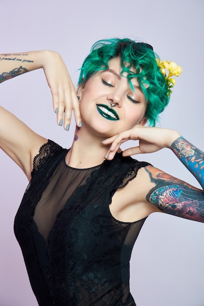 Mulher com coloração verde criativa e maquiagem, fios de cabelo tóxicos. cabelo encaracolado de cor brilhante na cabeça da menina, maquiagem profissional