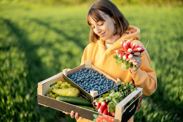 Mulher com comida fresca em terras agrícolas