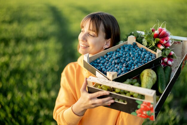 Mulher com comida fresca em terras agrícolas