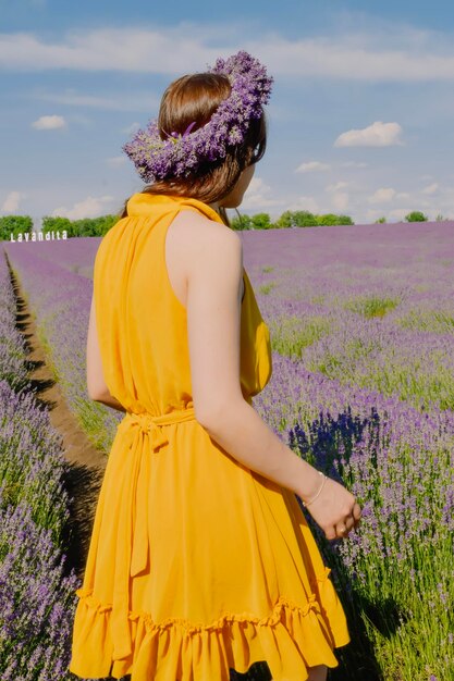 Mulher com coroa de flores no campo de lavanda