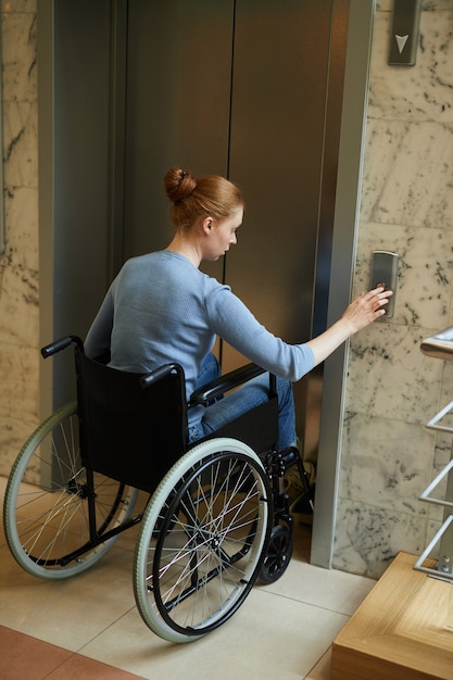 Mulher com deficiência usando o elevador