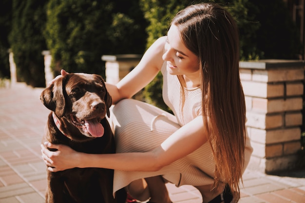 Mulher, com, dela, cachorro grande, ligado, cidade, promenade. chocolate labrador retriever