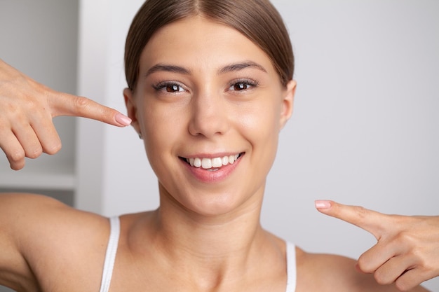 Mulher com dentes brancos fortes olhando para a câmera e sorrindo