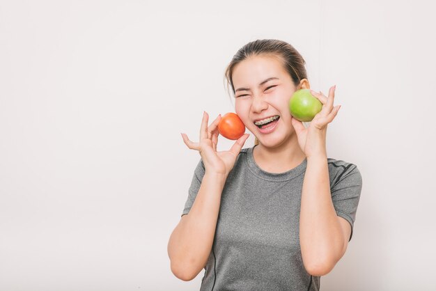 Mulher, com, detal, cintas, tendo divertimento, com, maçã verde, e, tomate