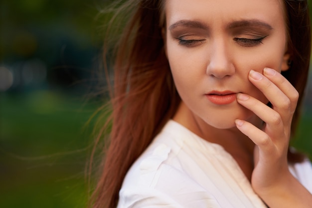 Mulher com dor de dente. Conceito de tristeza de problemas de dor em odontologia