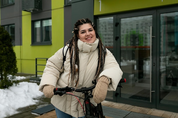 Mulher com dreadlocks andando de bicicleta