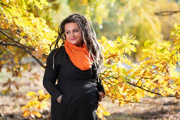 Mulher com dreadlocks ao ar livre no outono, conceito de cultura jovem