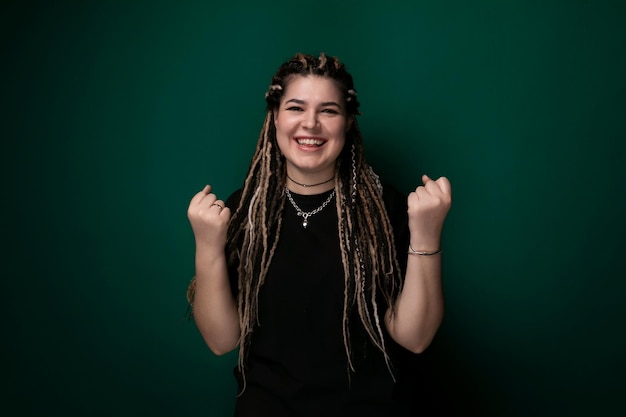 Mulher com dreadlocks em frente à parede verde