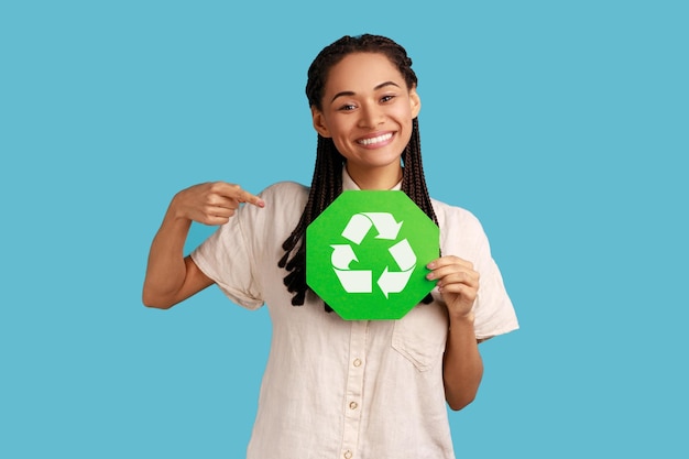 Foto mulher com dreadlocks pretos apontando para o símbolo de reciclagem verde em seu conceito de ecologia de mãos