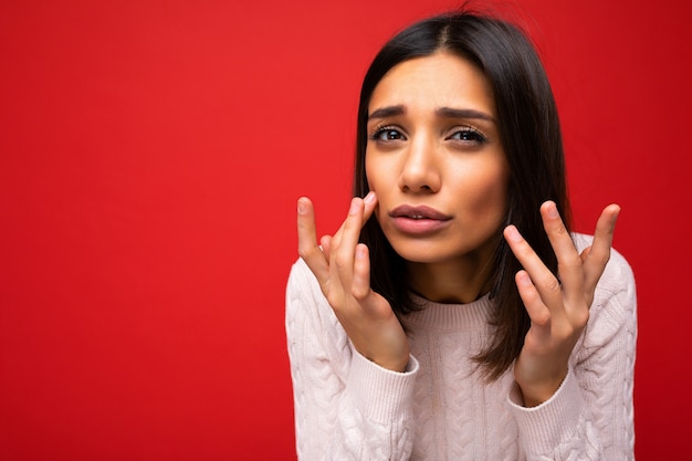 Foto mulher com emoções sinceras vestindo roupas casuais isoladas sobre o vermelho