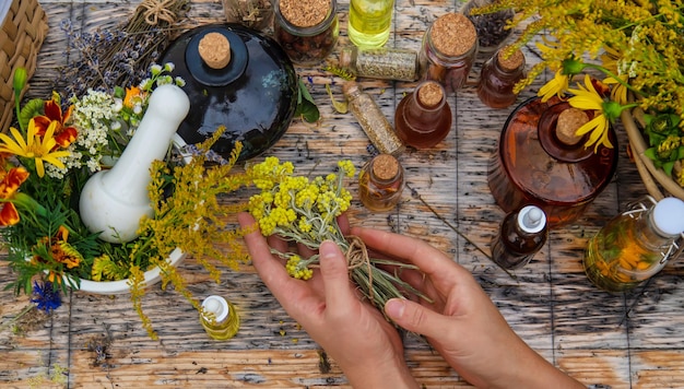 Foto mulher com ervas medicinais e tinturas foco seletivo