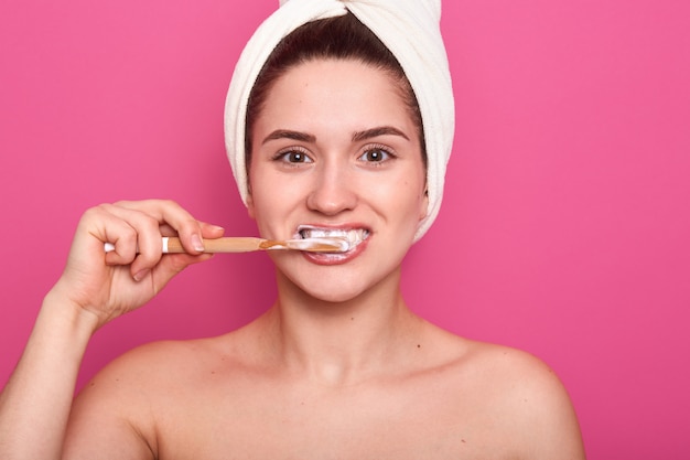 Mulher com escova de dentes, limpando os dentes