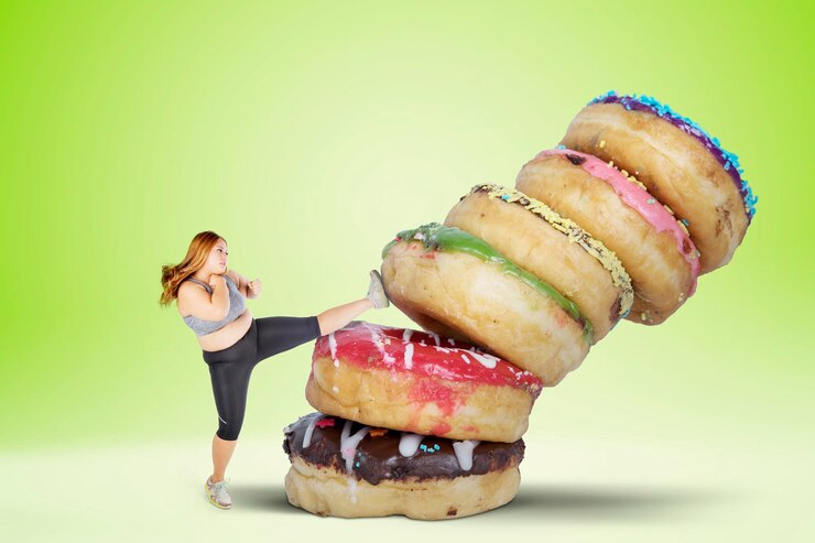 Foto mulher com excesso de peso chutando donuts sobre fundo branco