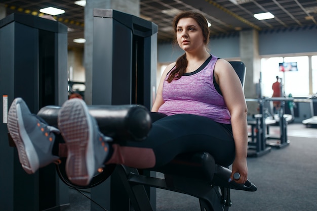 Foto mulher com excesso de peso com exercícios físicos, exercícios na academia, treinamento ativo