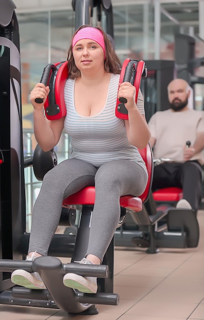 Mulher com excesso de peso treinando na academia