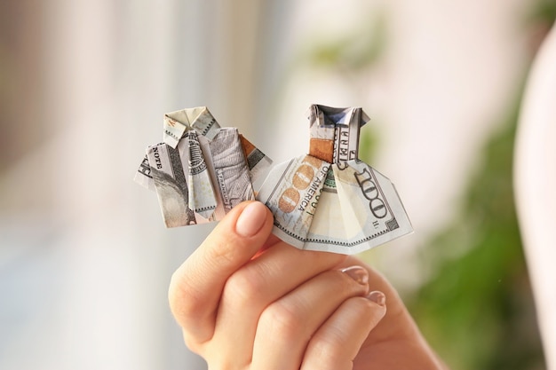 Mulher com figuras de origami feitas de notas de dólar em casa, close-up
