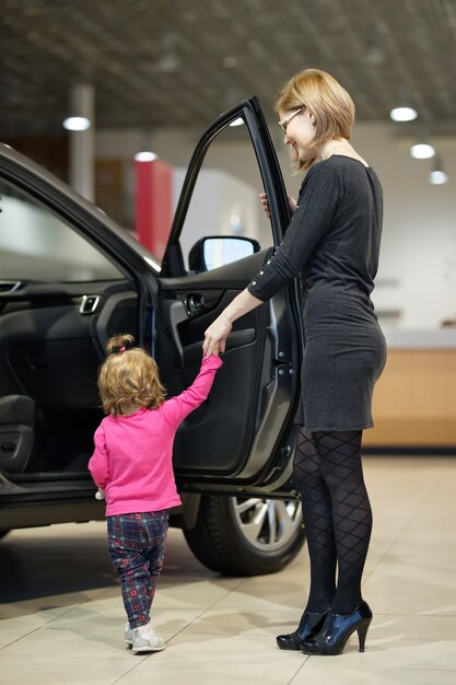 Mulher com filha escolhe carro na concessionária