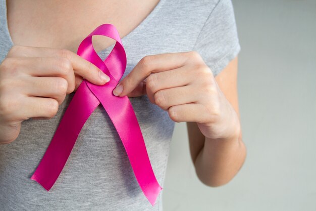 mulher com fita de conscientização de câncer de mama rosa