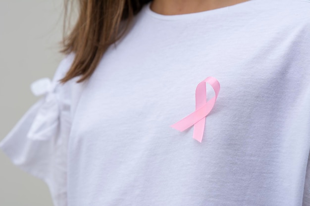 Mulher com fita rosa para apoiar a causa do câncer de mama