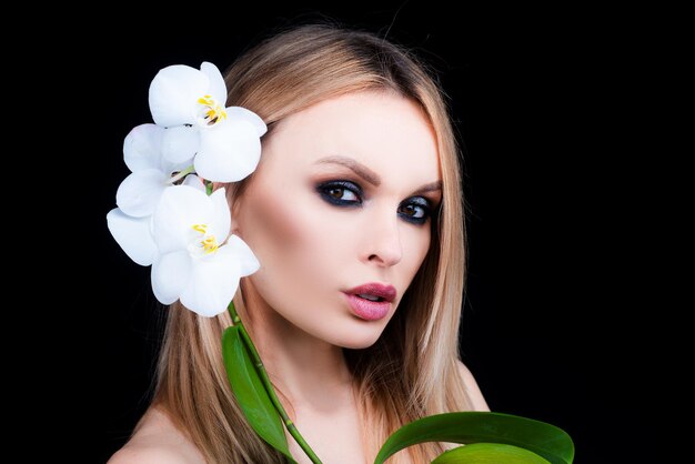 Mulher com flor de orquídea Produtos cosméticos Cuidados de saúde de beleza