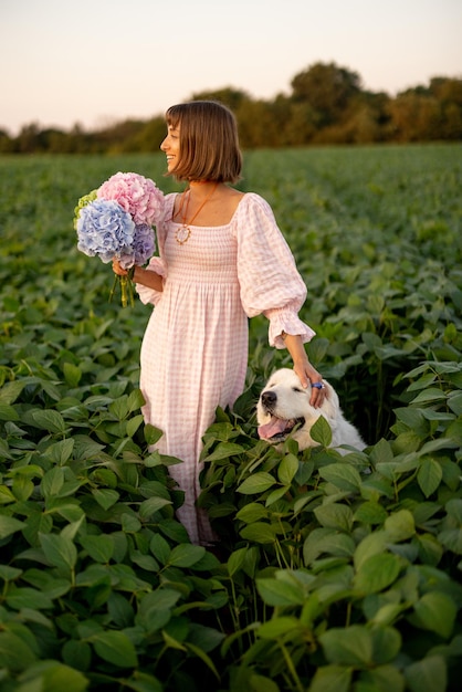 Mulher com flores e cachorro em um campo