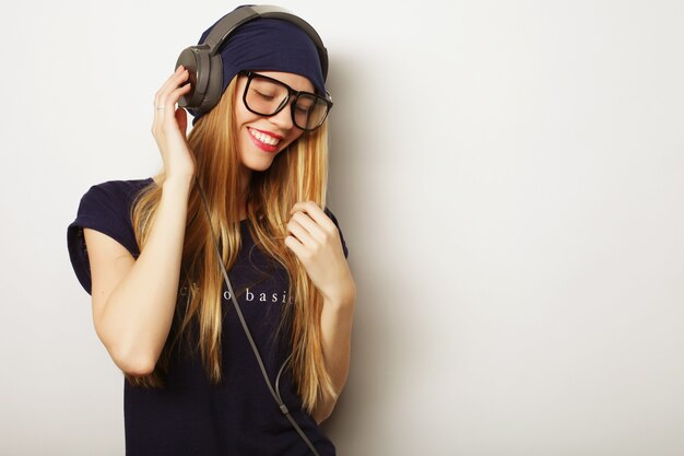 Mulher com fones de ouvido, ouvindo música. Menina adolescente de música dançando contra branco.