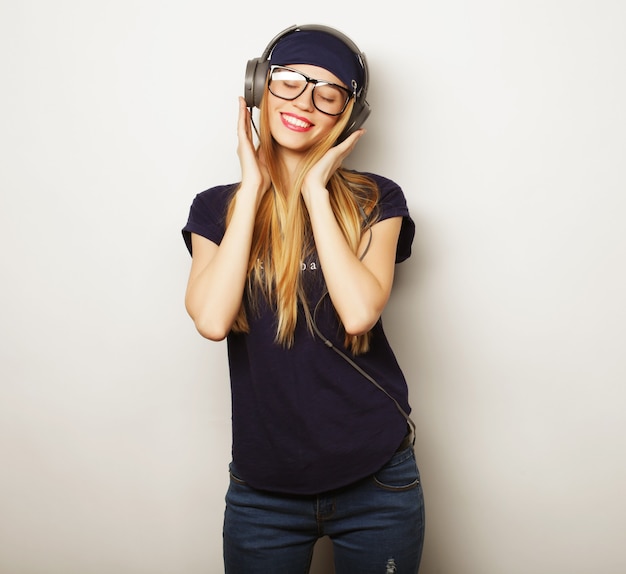 Mulher com fones de ouvido, ouvindo música. menina adolescente de música dançando contra branco.