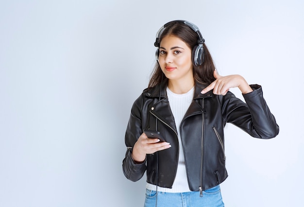 mulher com fones de ouvido usando seu smartphone para definir a lista de reprodução.