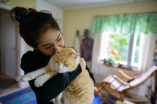 Foto mulher com gato em casa