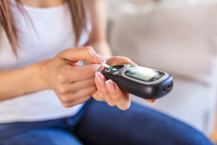Foto mulher com glicosímetro, verificando o nível de açúcar no sangue em casa. diabetes, conceito de saúde. jovem mulher usando glicosímetro digital em casa. controle de diabetes