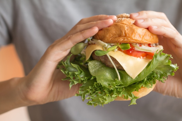 Mulher com hambúrguer no horário do almoço