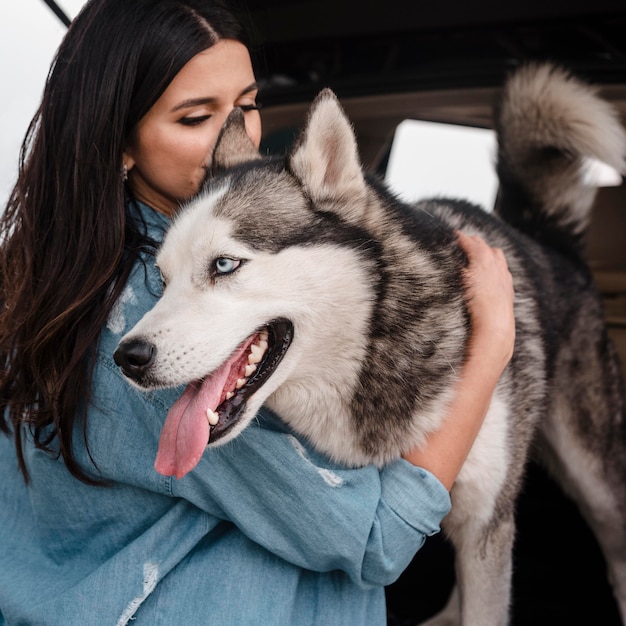 Mulher com husky viajando de carro