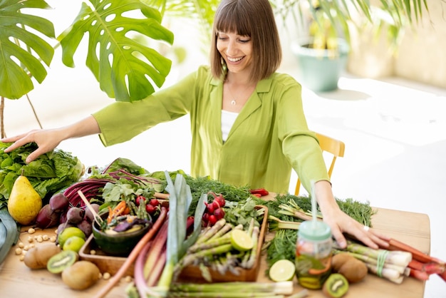 Mulher com ingredientes alimentares saudáveis frescos dentro de casa