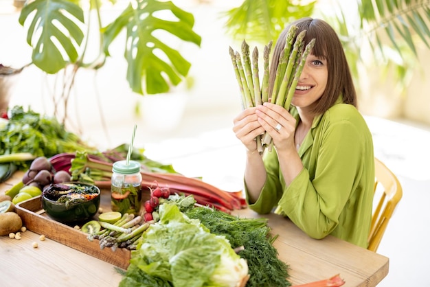 Mulher com ingredientes alimentares saudáveis frescos dentro de casa