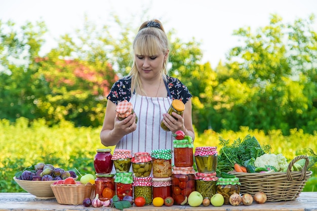 Mulher com jarra de legumes preservados para o inverno Foco seletivo