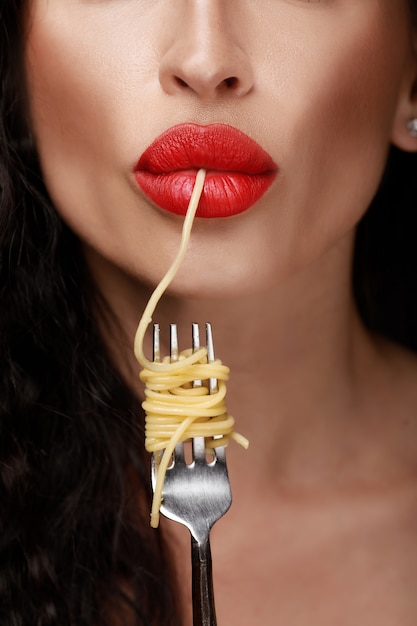 Foto mulher com lábios vermelhos comendo espaguete