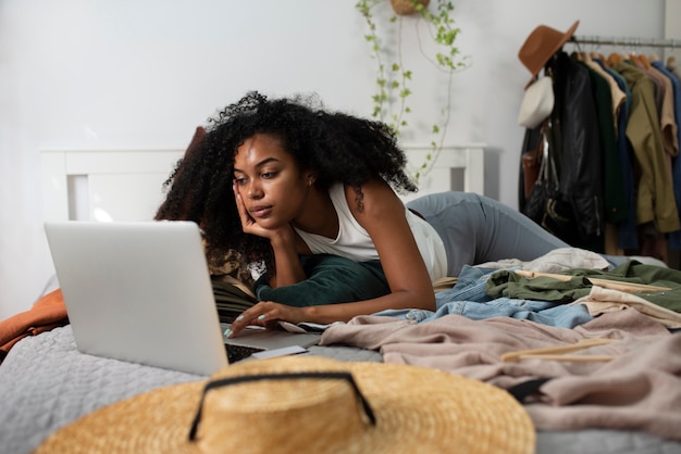 Foto mulher com laptop na cama tiro completo