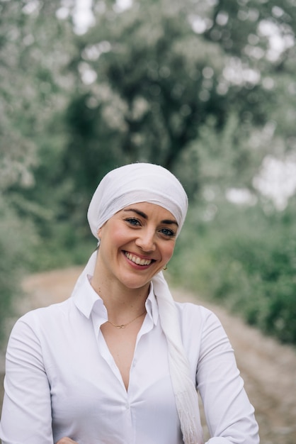 Mulher com lenço branco na floresta