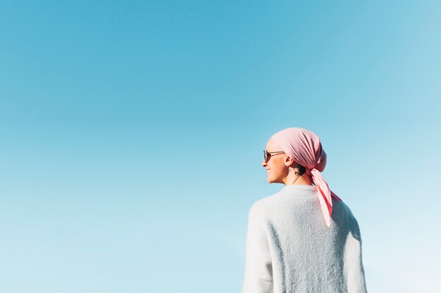 Mulher com lenço rosa, tem câncer