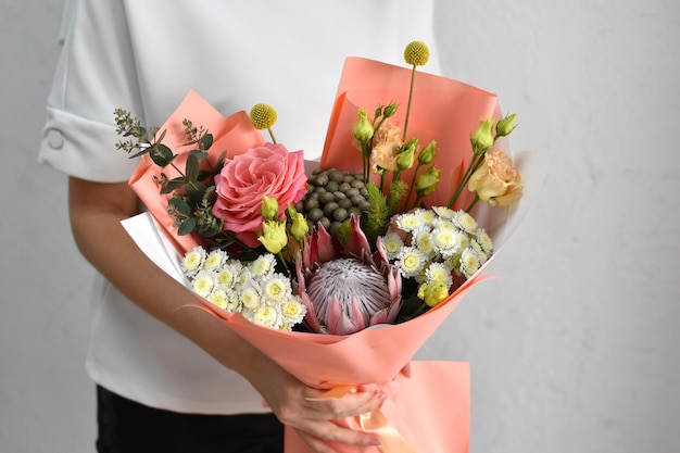 Mulher com lindas flores nas mãos dentro de casa buquê de flores para floricultura