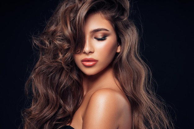 Mulher com maquiagem brilhante de cabelo preto comprido isolada em preto