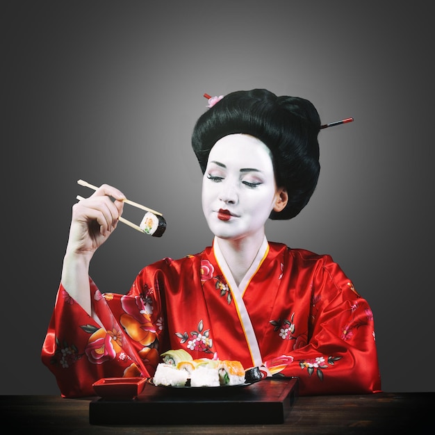 Mulher com maquiagem de gueixa comendo sushi