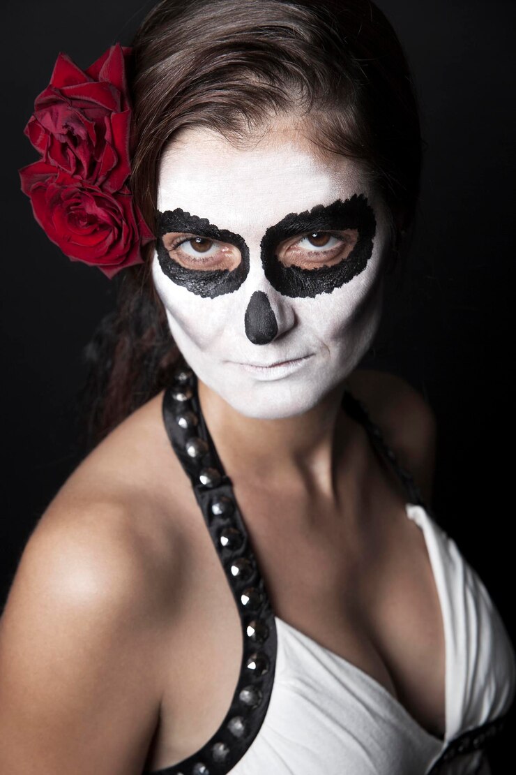 Foto mulher com maquiagem de la santa muerte com rosas vermelhas em frente a um fundo preto