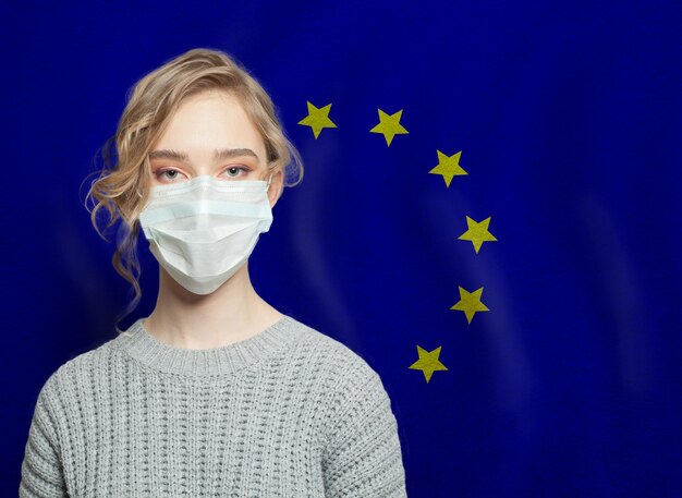 Foto mulher com máscara facial com bandeira da ue conceito de proteção contra a epidemia de gripe e o vírus