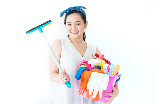 Mulher com material de limpeza e detergentes em fundo branco para limpar a casa