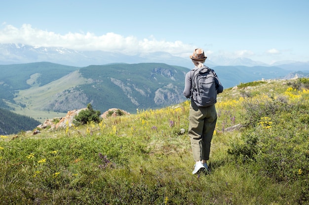 Mulher com mochila caminhando nas montanhas