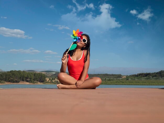 Mulher com moinho de vento de brinquedo na praia