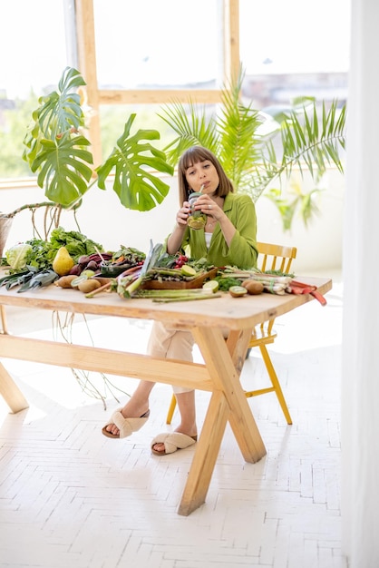 Mulher com muitos ingredientes de alimentos frescos dentro de casa