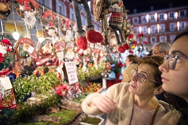 Foto mulher com neta comprando decorações durante o natal à noite