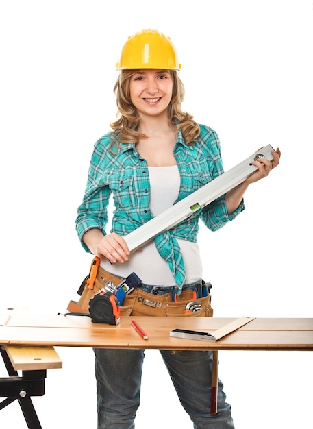 Mulher com nível de bolha e capacete no trabalho